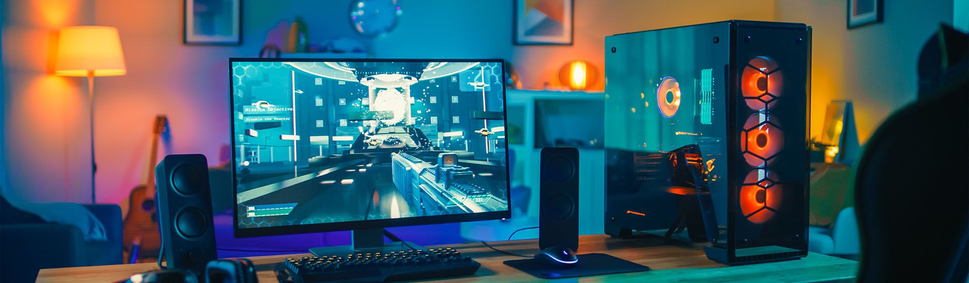 Quarto gamer com PC, monitor rodando um jogo, teclado e caixas de som