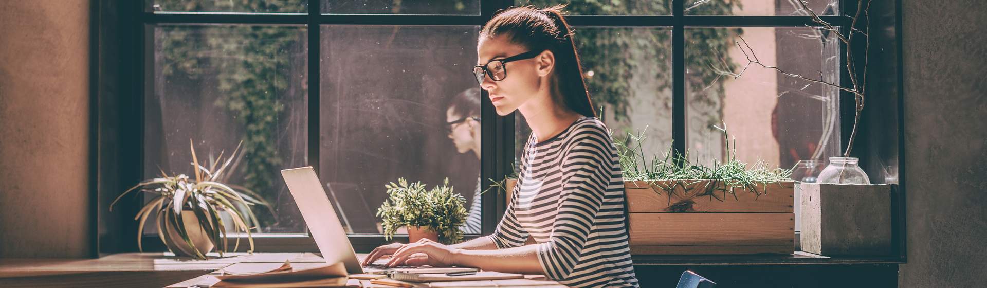 Mulher branca em escritório usando notebook para trabalho