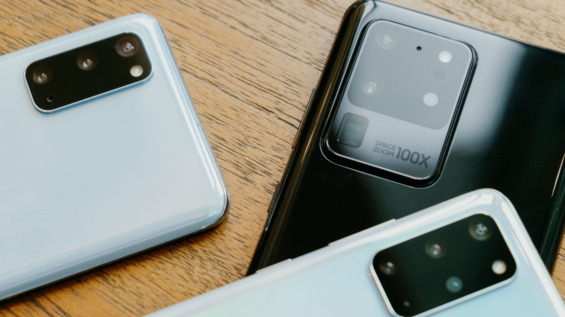 Três smartphones da Samsung, que têm os melhores processadores de celular, apoiados em uma mesa