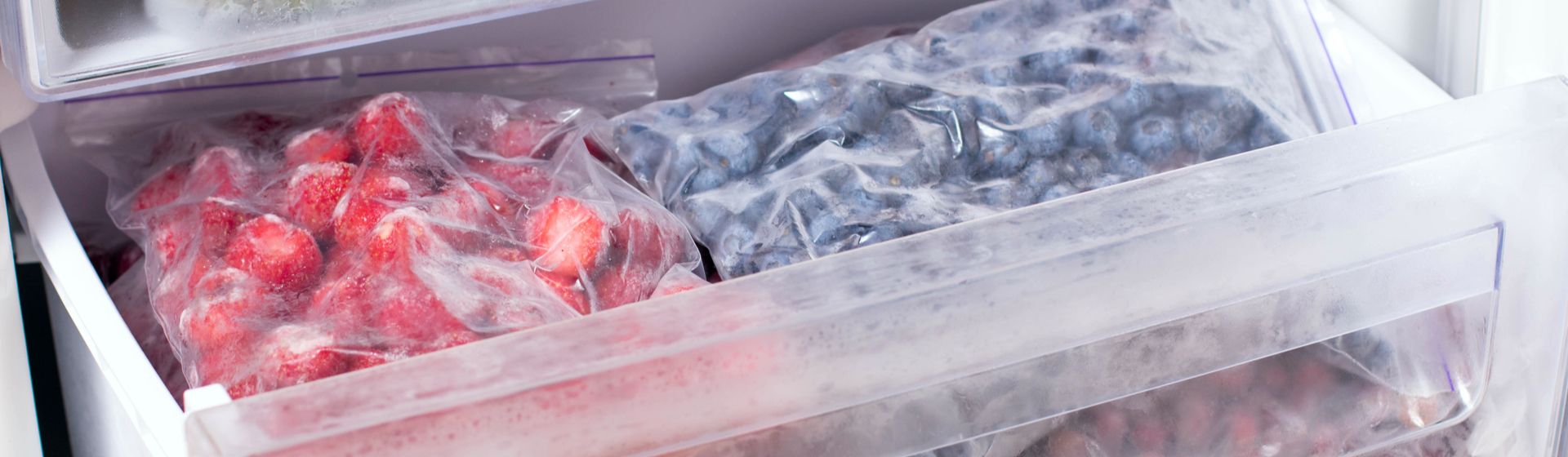 Frutas congeladas na gaveta de um freezer