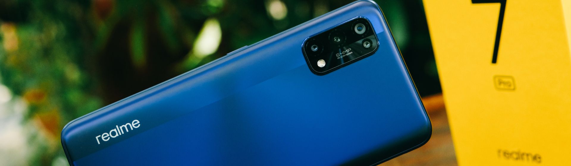 Celular Realme 7 na cor azul inclinado ao lado da caixa