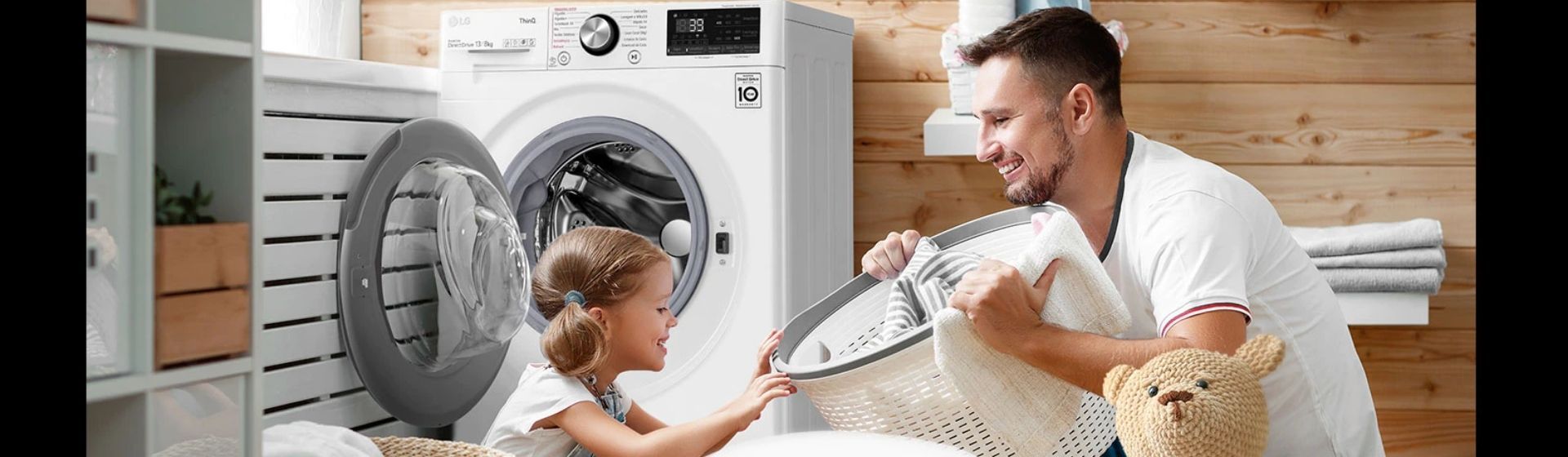 Homem com filha em lavanderia, com cesto de roupa suja e lava e seca LG ao fundo