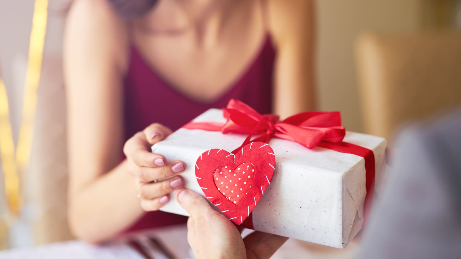 Imagem de uma pessoa entregando presente para outra para ilustrar matéria de celulares para o Dia dos Namorados