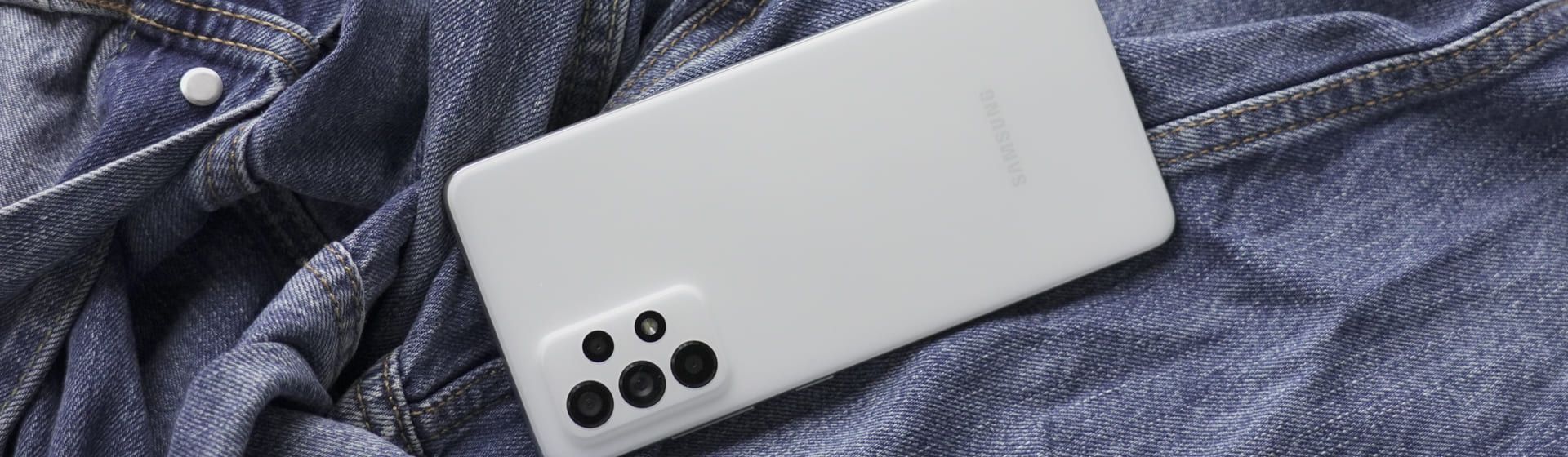 Celular Samsung A72 de cor branca sobre tecido jeans
