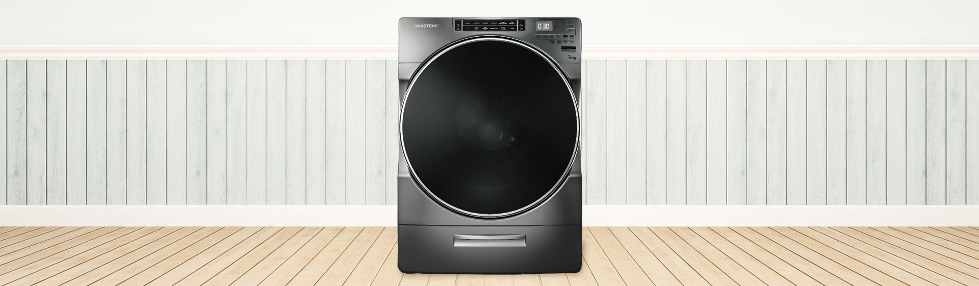 Máquina de lavar Brastemp 15kg Titanium centralizada sob um piso de taco com parede azul de fundo.