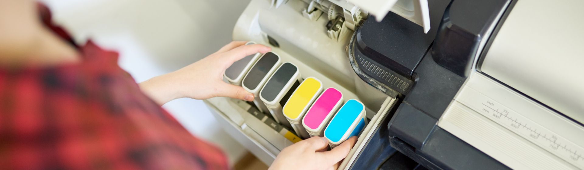 Impressora toner aberta com três cartuchos pretos, um amarelo, um rosa e um azul