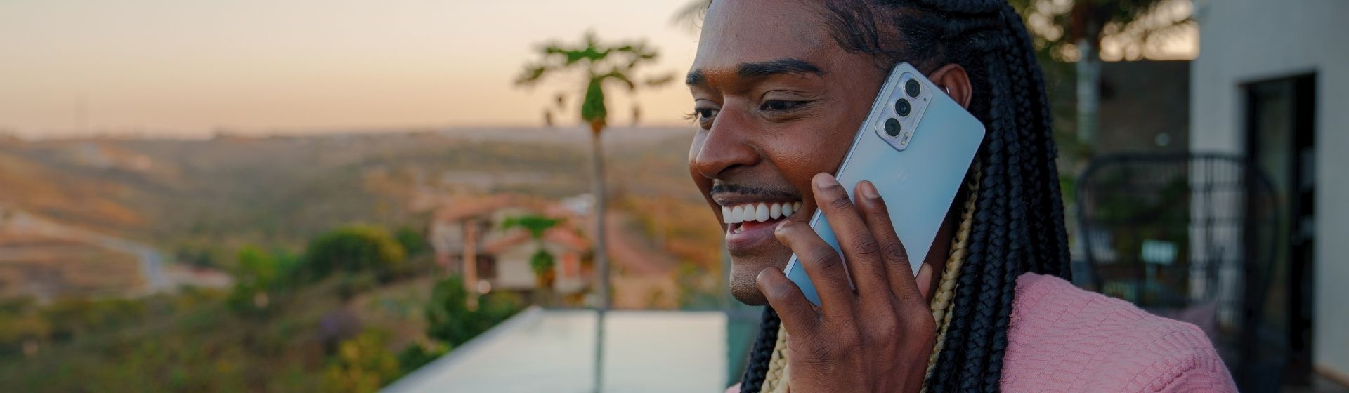Foto mostra pessoa sorrindo com Motorola Edge 20 junto à orelha