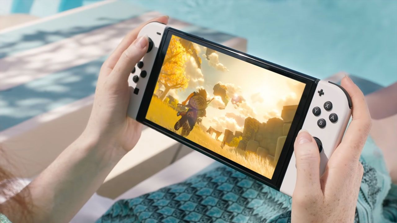 Nintendo Switch OLED em mãos, com jogo na tela.