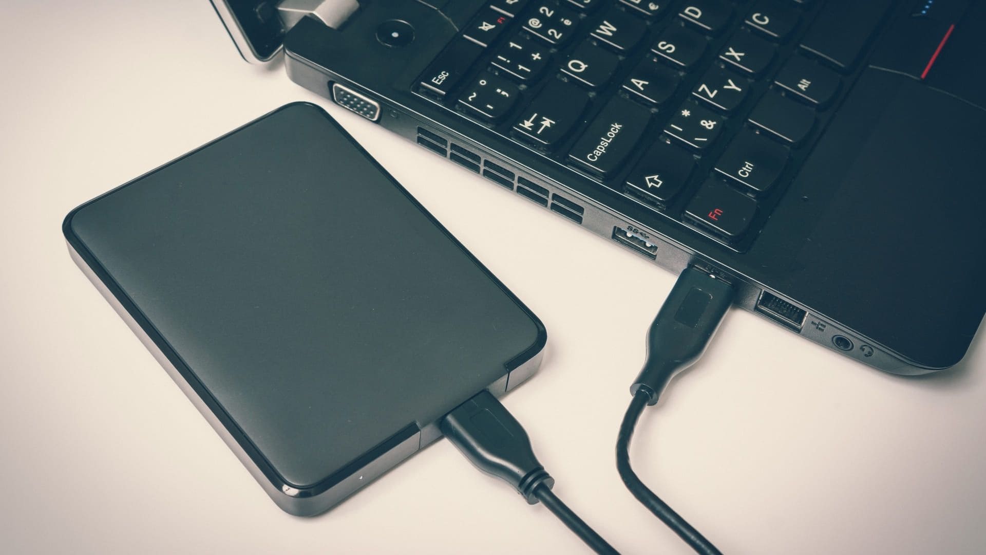 HD externo 1TB preto conectado a notebook preto