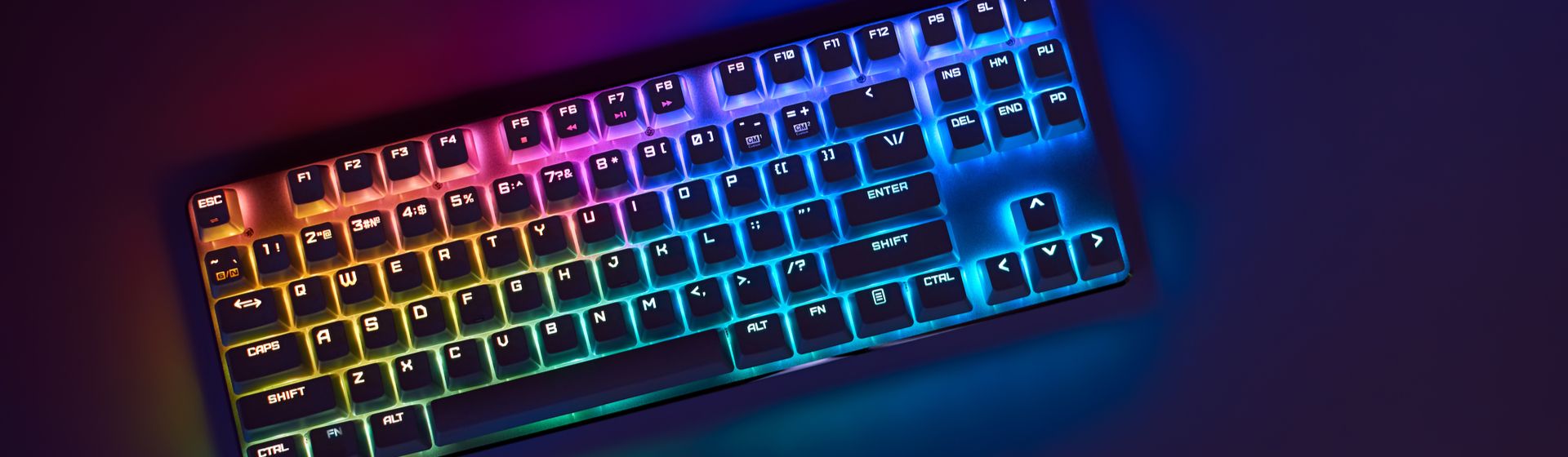 Teclado gamer com iluminação RGB em mesa preta