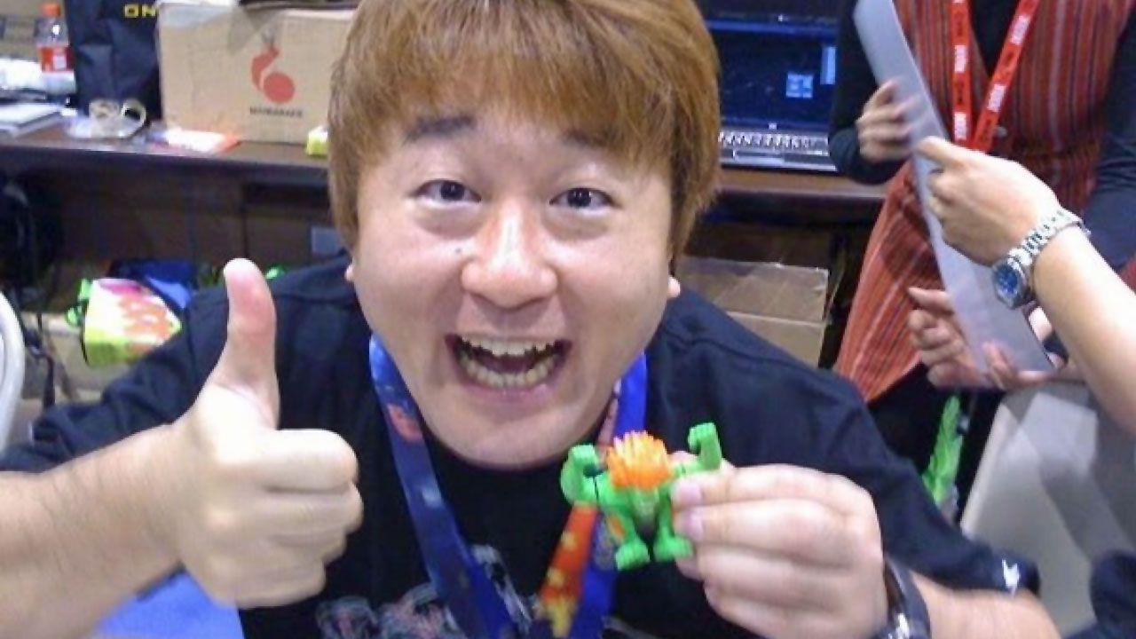 Yoshinori Ono segurando um boneco de Street Fighter