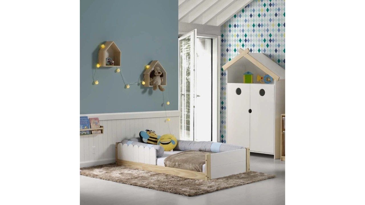 Cama Montessoriana Cerquinha sobre tapete, com almofadas em cima, em um quarto decorado.