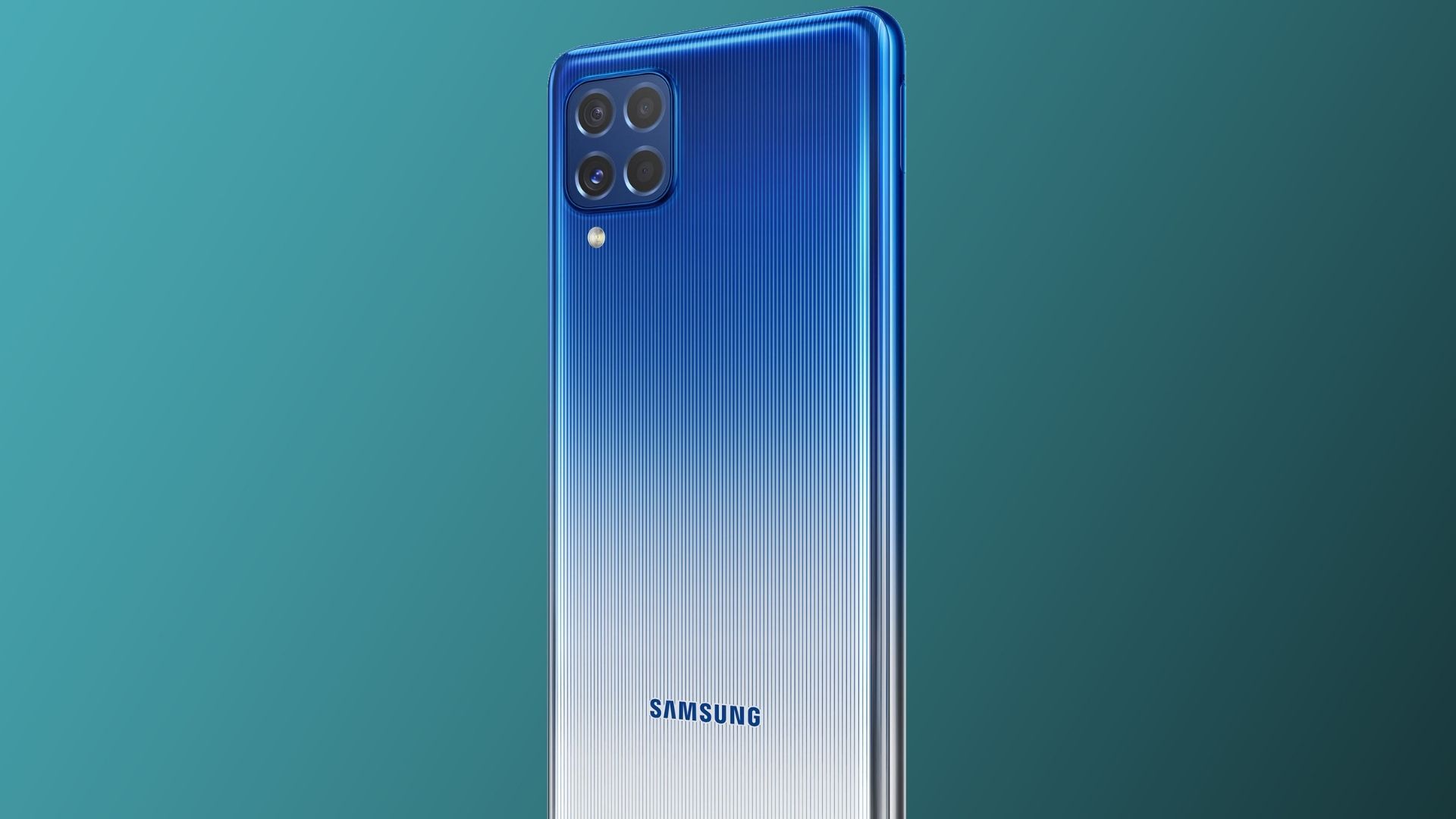 Celular Galaxy M62 na versão azul com traseira destacada e em fundo verde