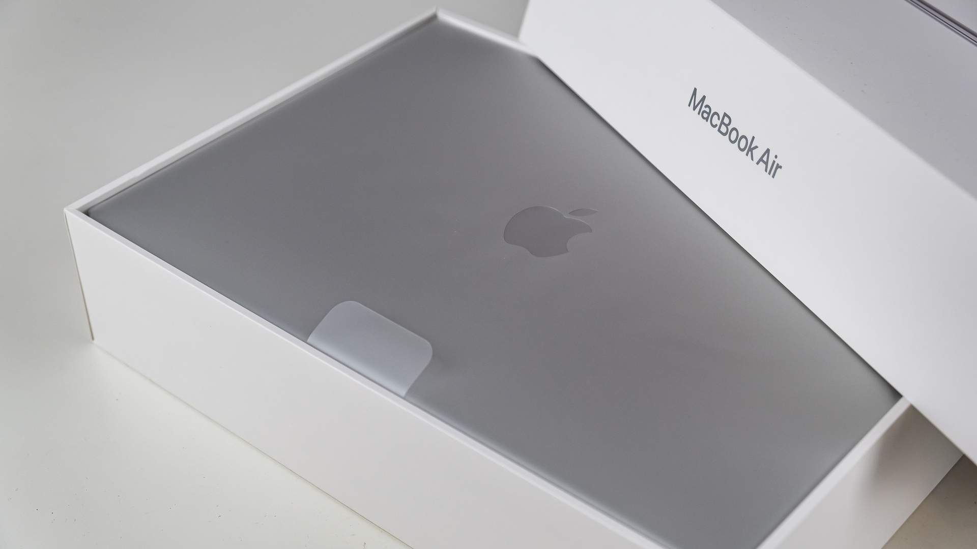 Caixa branca do MacBook Air aberta, mostrando o notebook da Apple na cor prateada