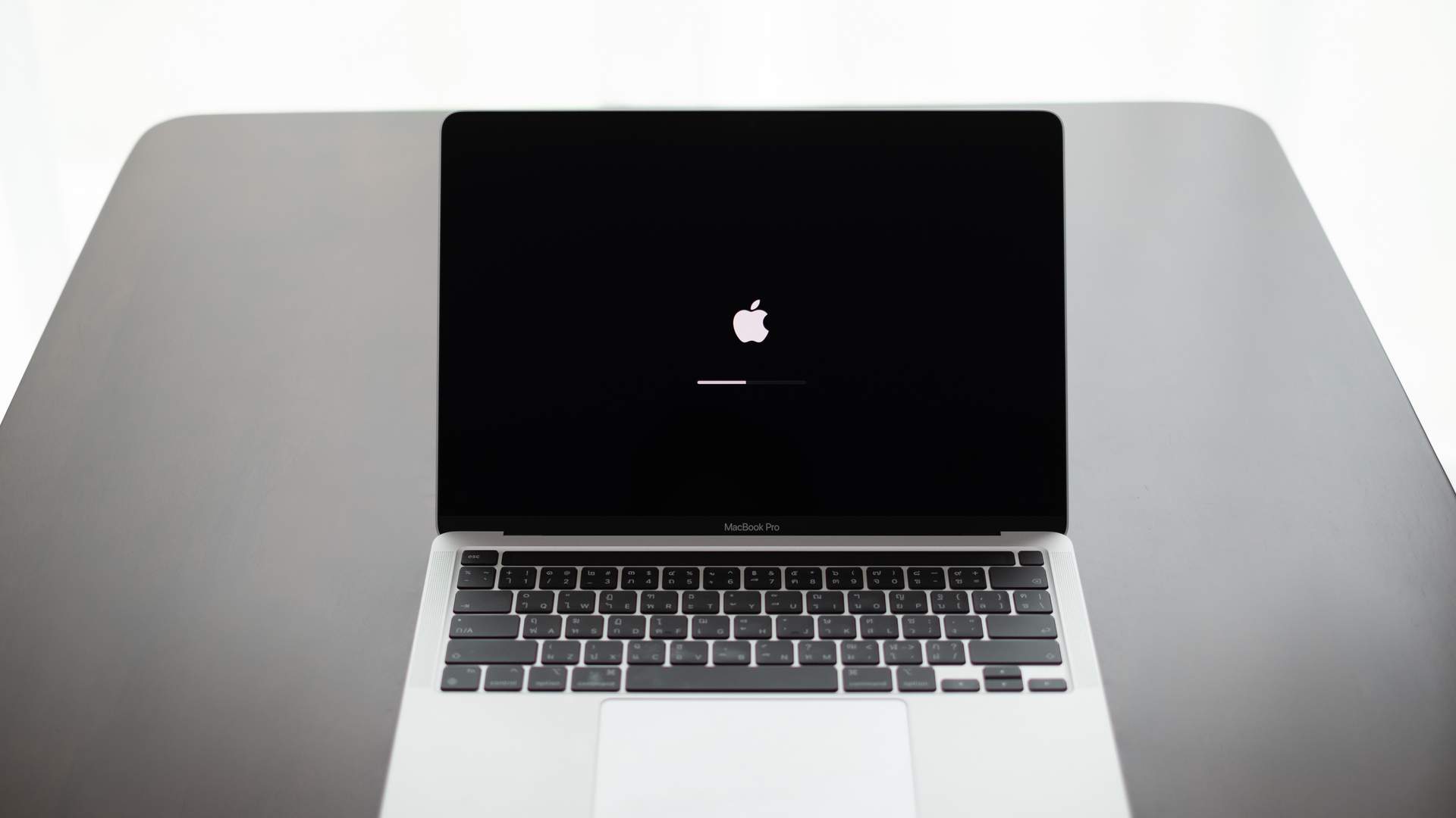 MacBook Pro prata com tela aberta mostrando tela de carregamento