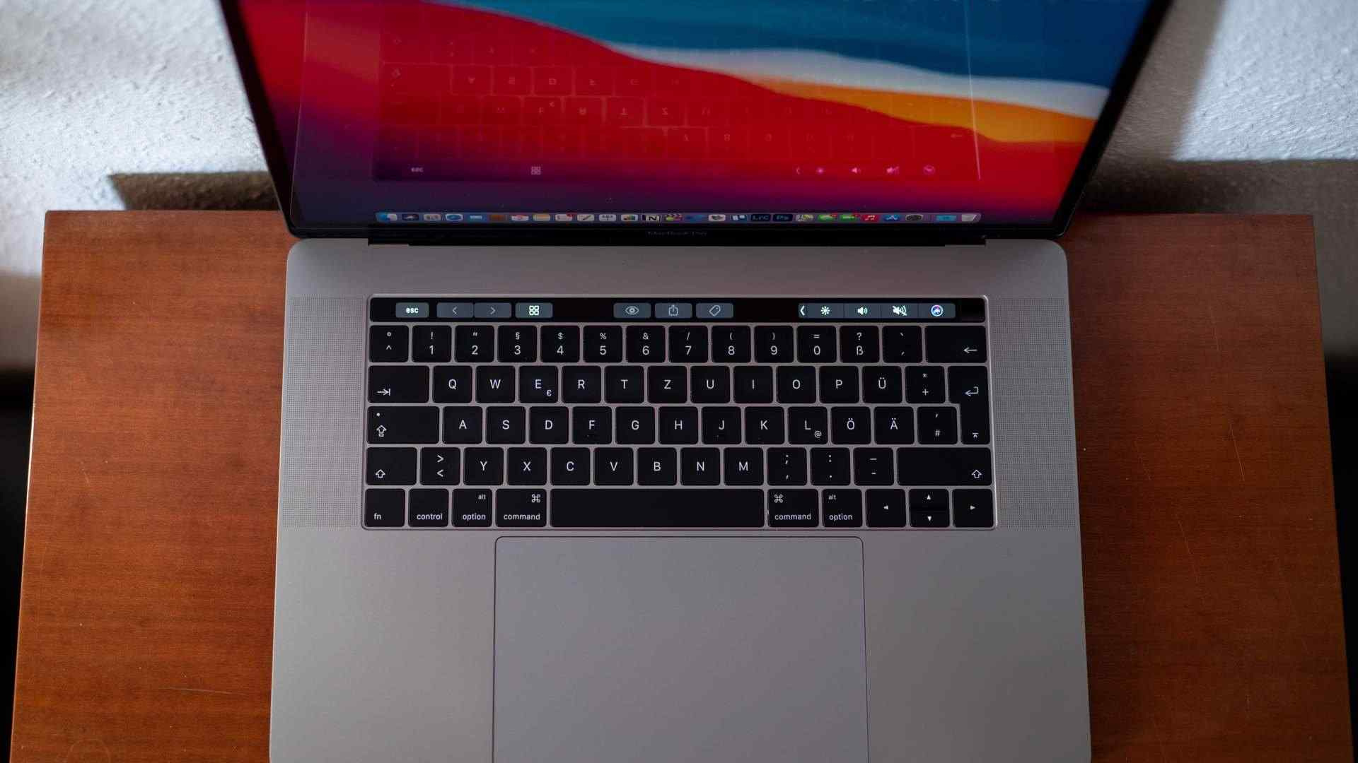 MacBook Pro prata aberto, com foco na touchbar acima do teclado