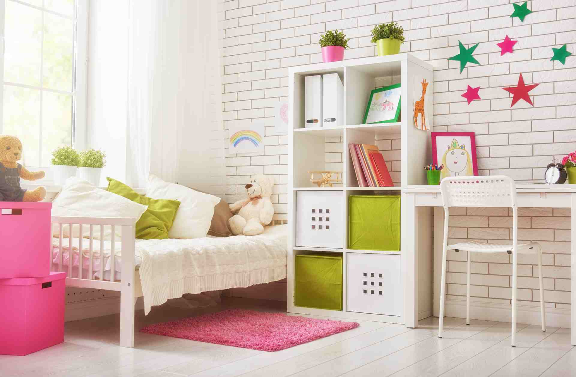 Quarto infantil com cama com travesseiros e ursinho de pelúcia, estante e escrivaninha