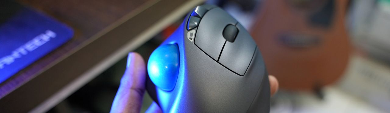 Uma pessoa segurando um mouse ergonômico cinza