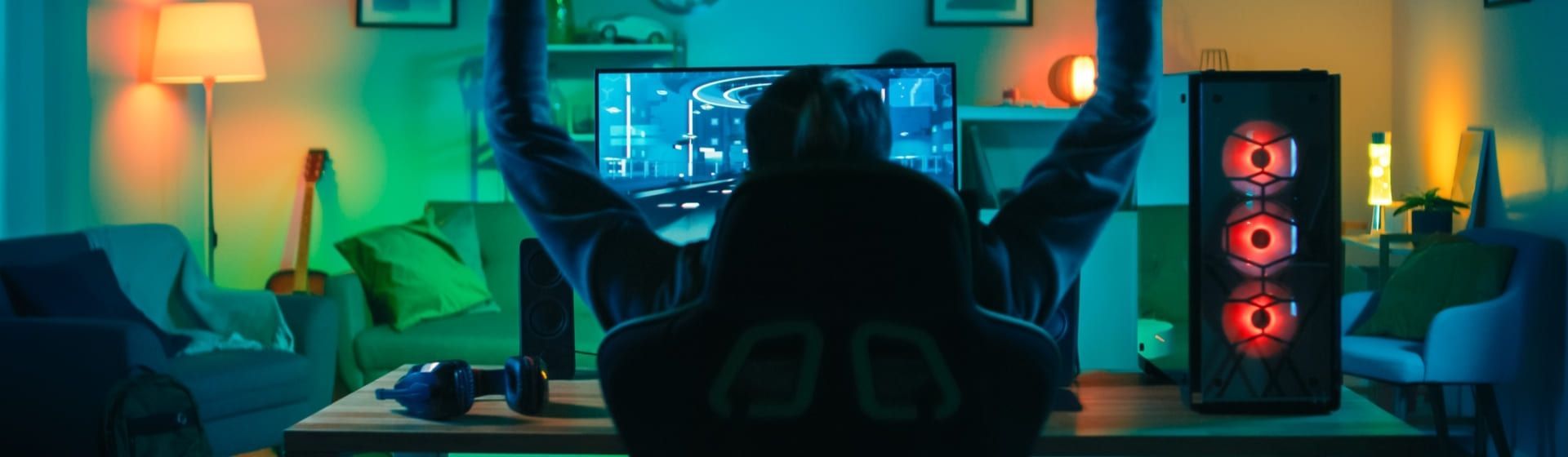 Homem de costas jogando em PC gamer barato e comemorando