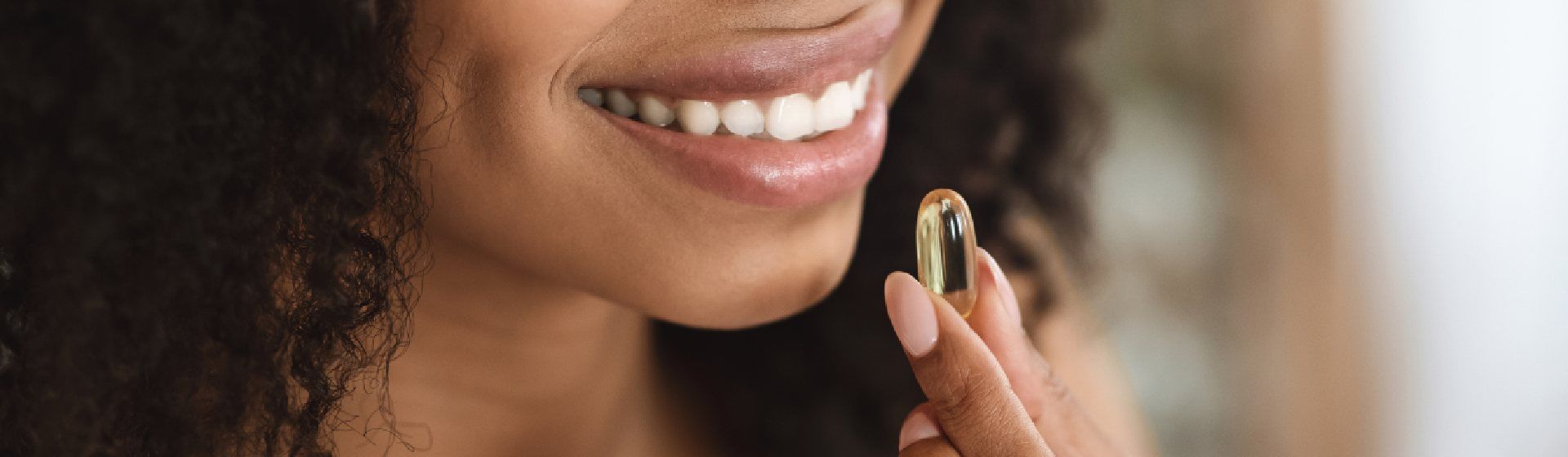 Mulher negra segurando um comprimido de vitamina