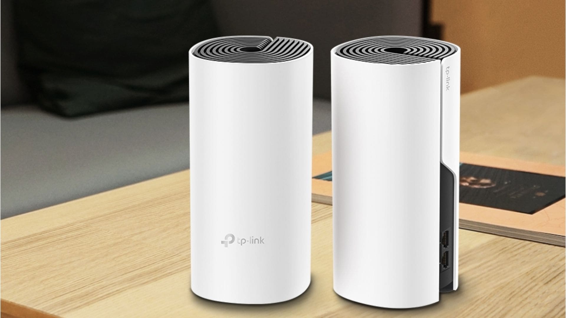 Dois modelos de roteador Mesh TP-Link brancos em cima de mesa de madeira