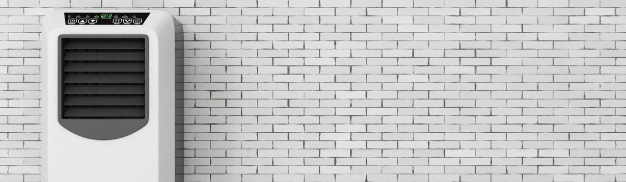 Climatizador de ar branco em frente a uma parede de tijolos brancos