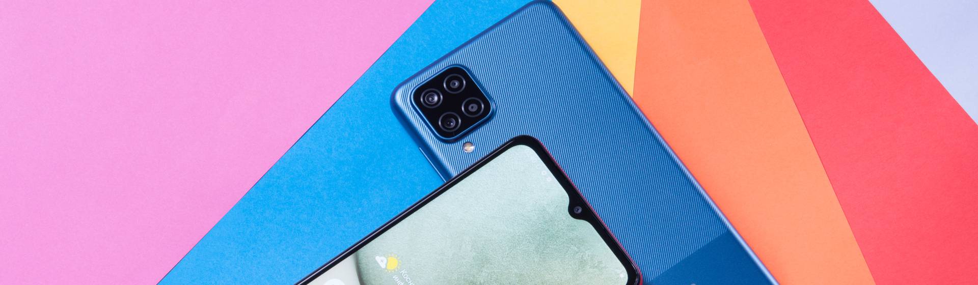Dois celulares Galaxy A12 em fundo colorido, sendo um com traseira destacada, e o outro de frente
