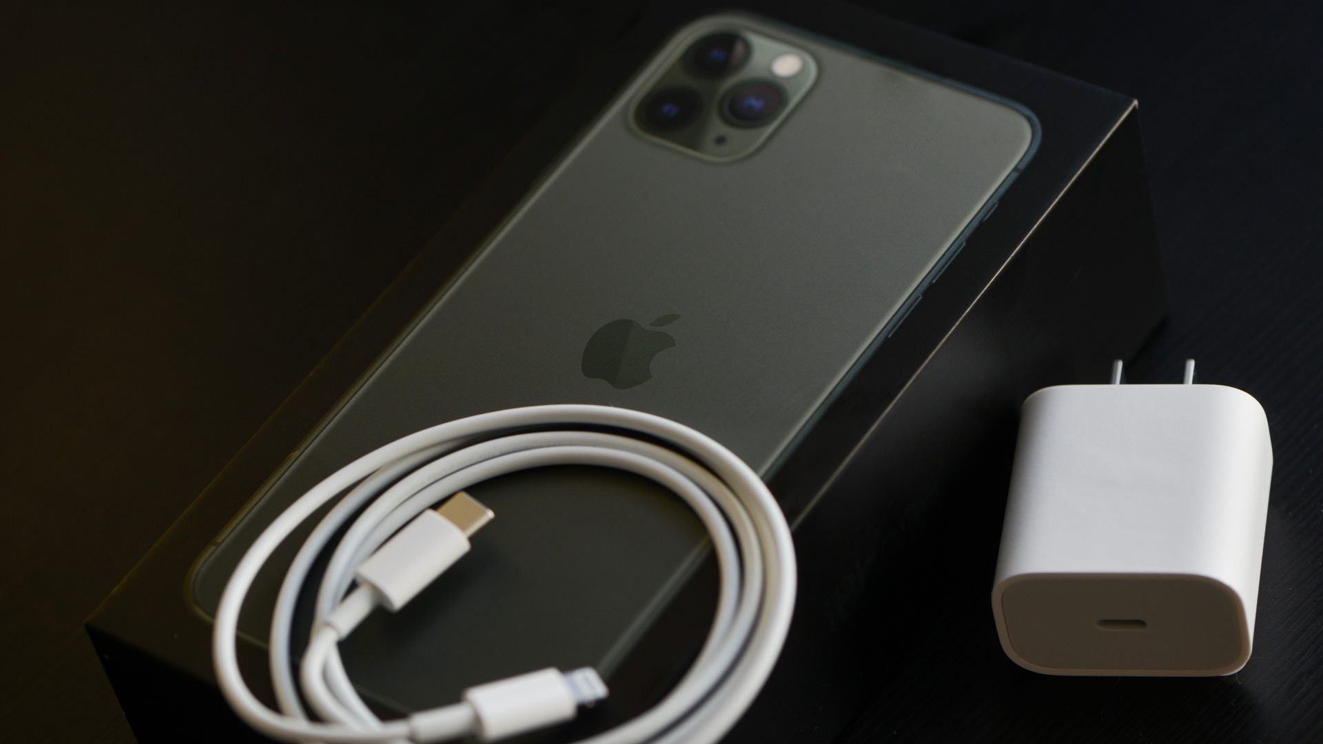 Imagem do iPhone 11 Pro Max com seu cabo USB e carregador