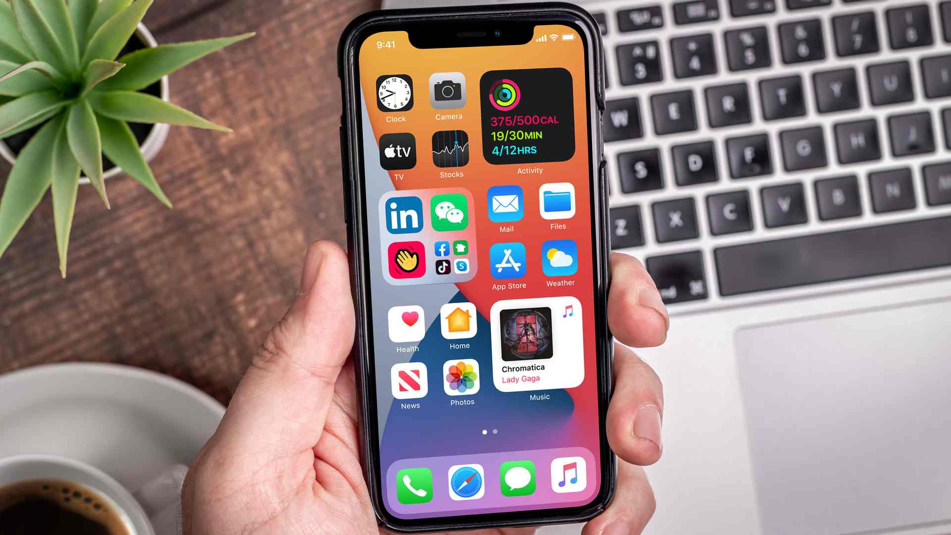 Pessoa segurando um iPhone com recursos do iOS na tela