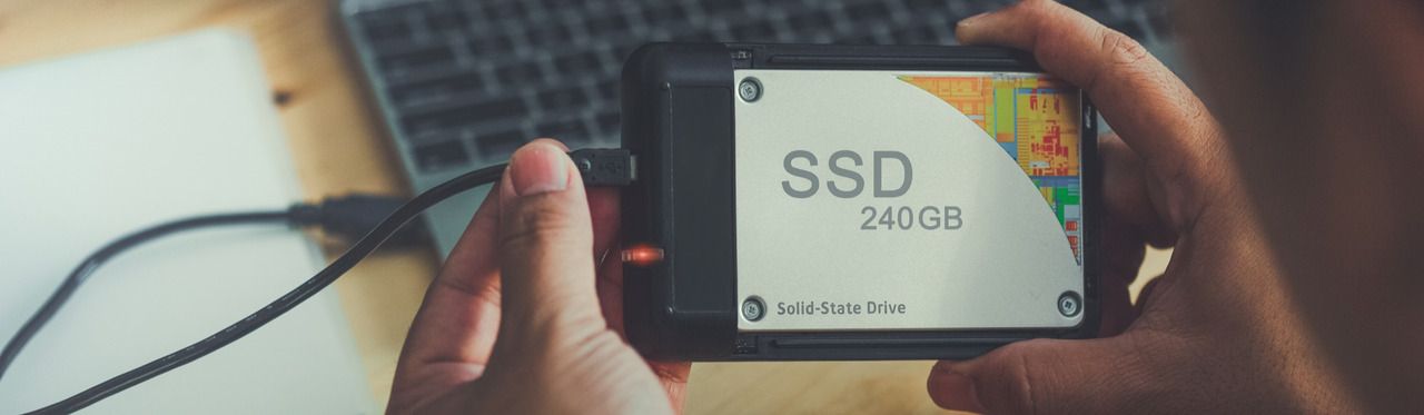 SSD externo sendo conectado ao notebook através de um cabo USB