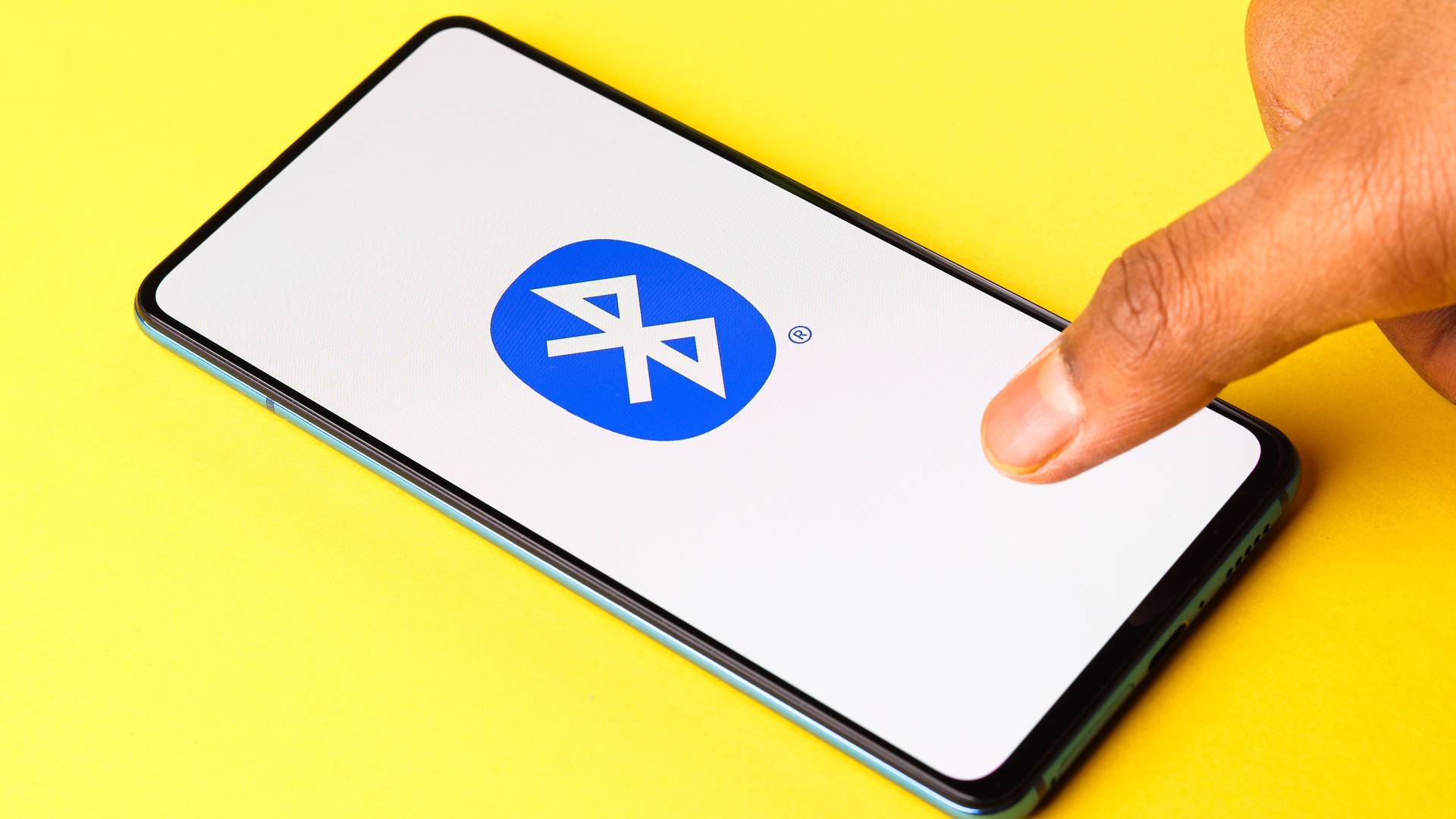 Celular preto com ícone do Bluetooth em fundo amarelo