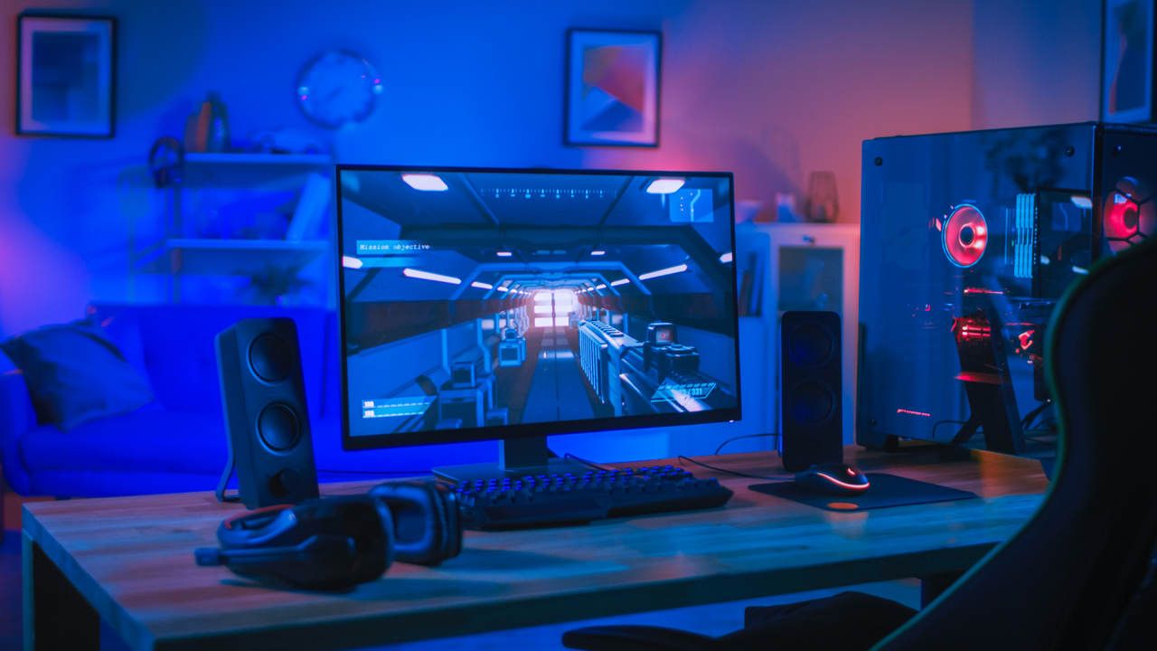 Monitor gamer sob mesa em quarto.