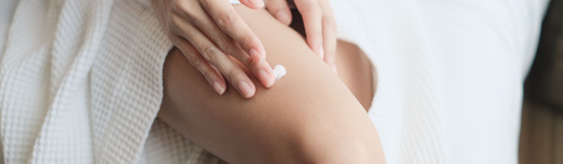 Mulher passando creme para celulite nas pernas