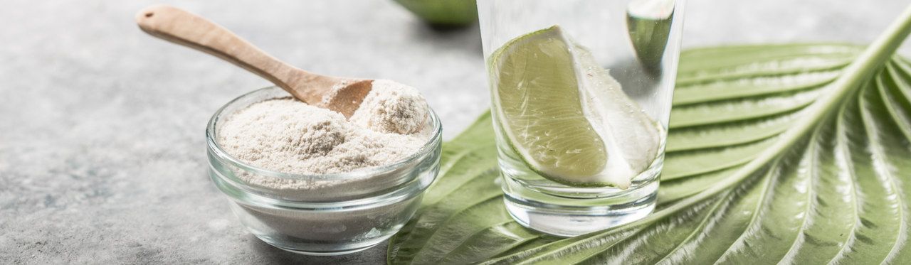 Colágeno em pó ao lado de copo com água e limão