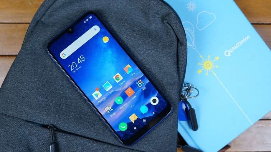 Redmi Note 8 apoiado em mochila ao lado de caixa do Snapdragon