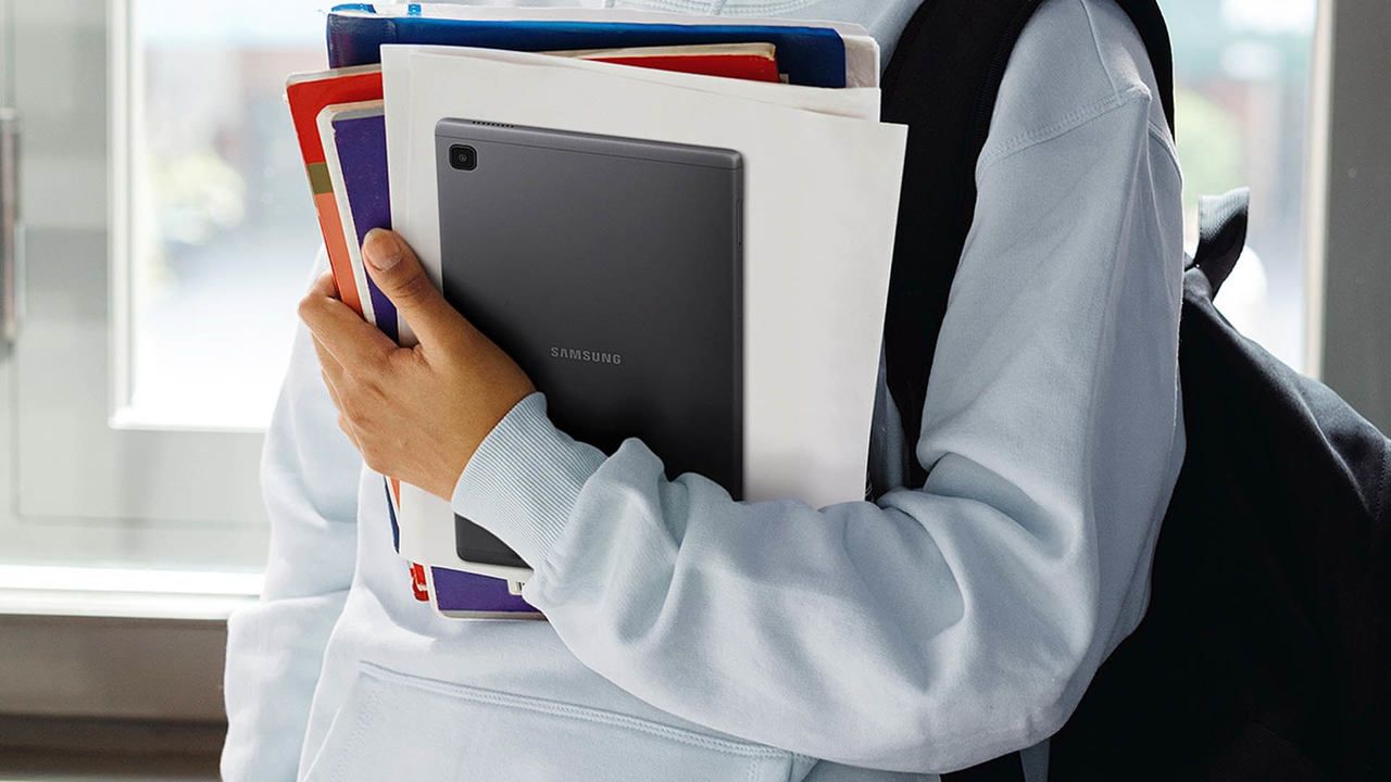 Pessoa segurando o Galaxy Tab A7 Lite junto a alguns livros