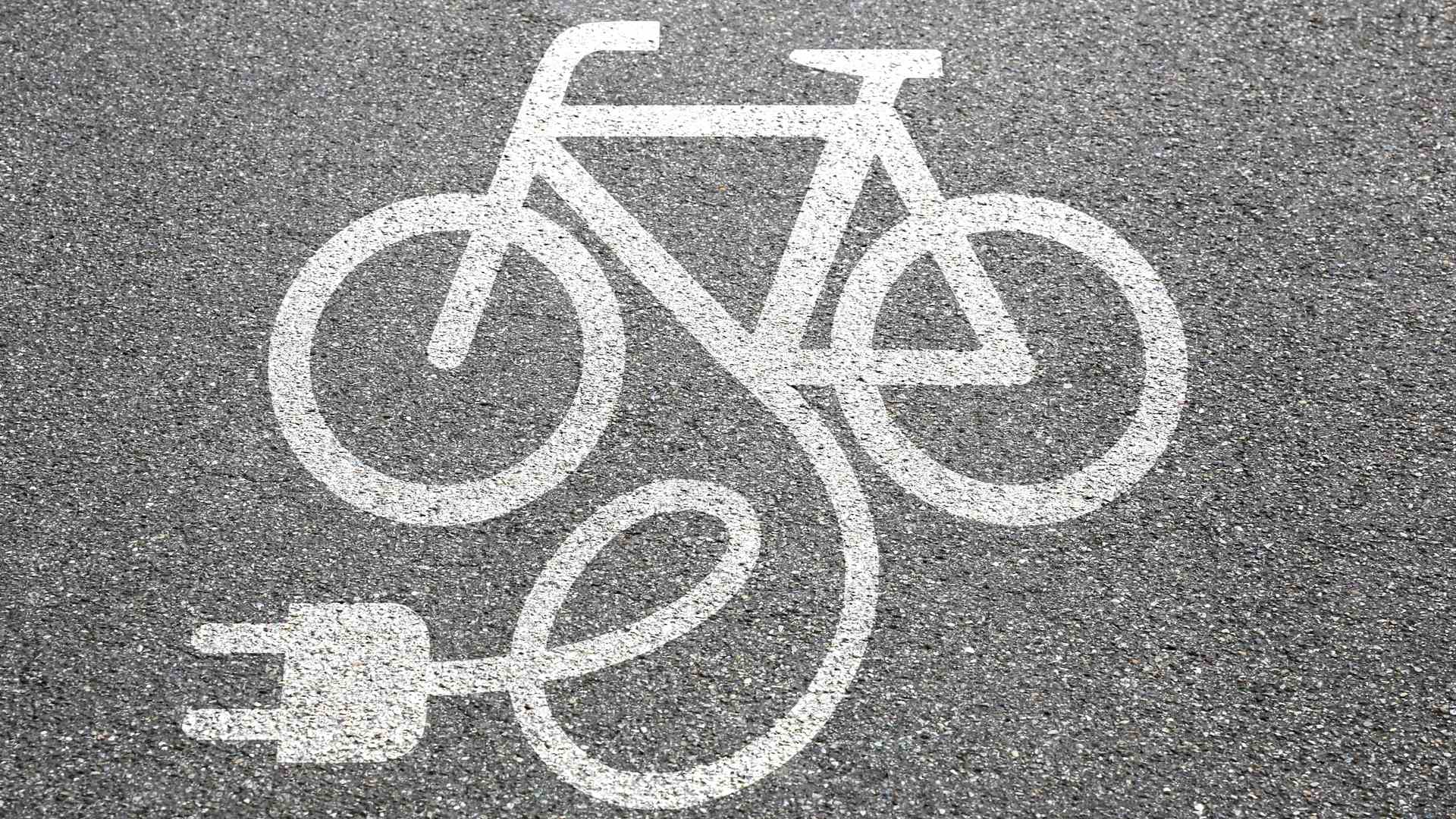 Uma bicicleta elétrica desenhada no asfalto