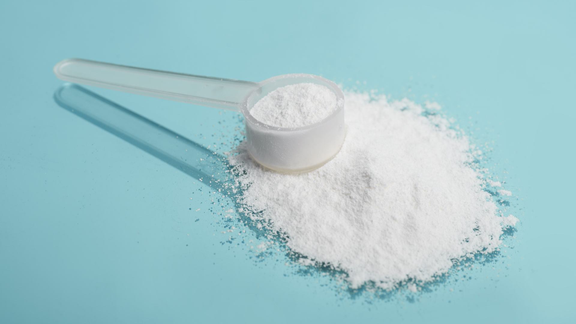 Maltodextrina e um medidor repleto do suplemento em superfície azul