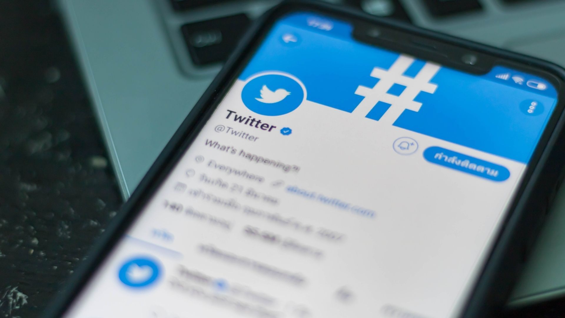 Celular aberto na página inicial da rede social Twitter em destaque