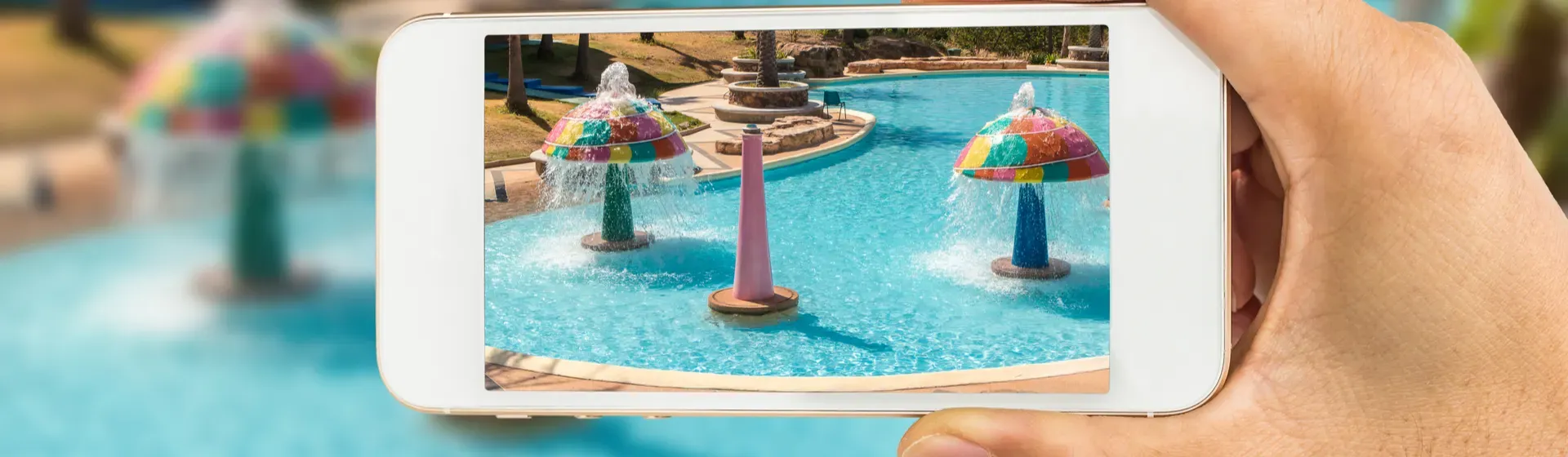 Mulher segurando um smartphone para tirar fotos na piscina