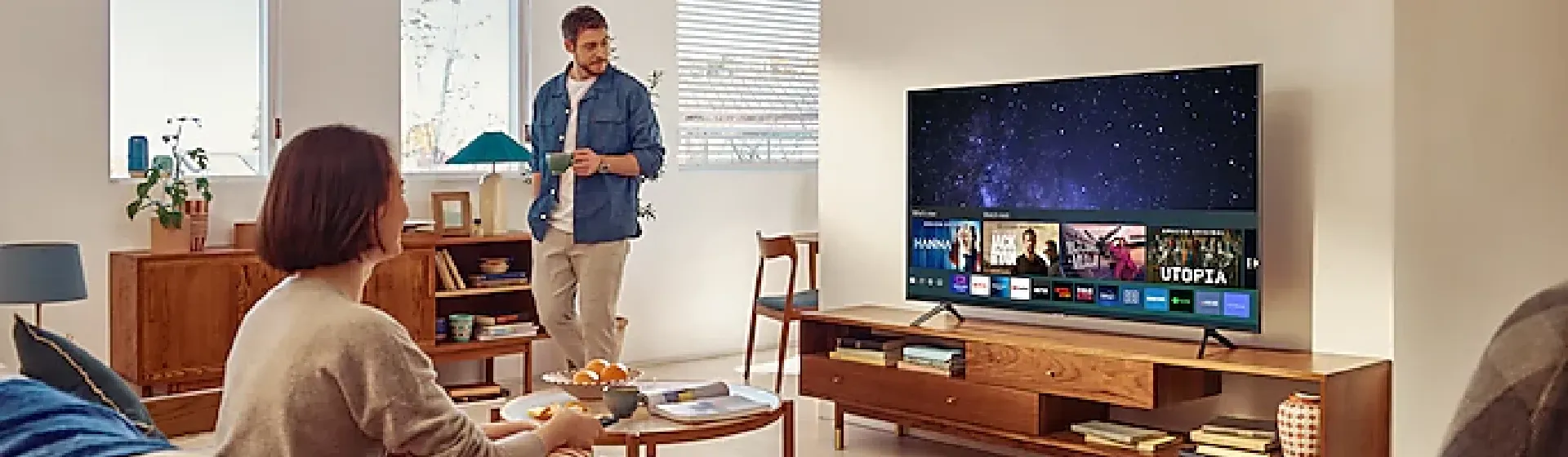TV Samsung AU7700 sobre rack de madeira em sala de estar