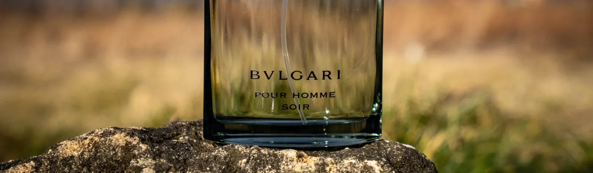  Perfume Bvlgari Aqva Pour Homme em cima de uma pedra com fundo ao ar livre