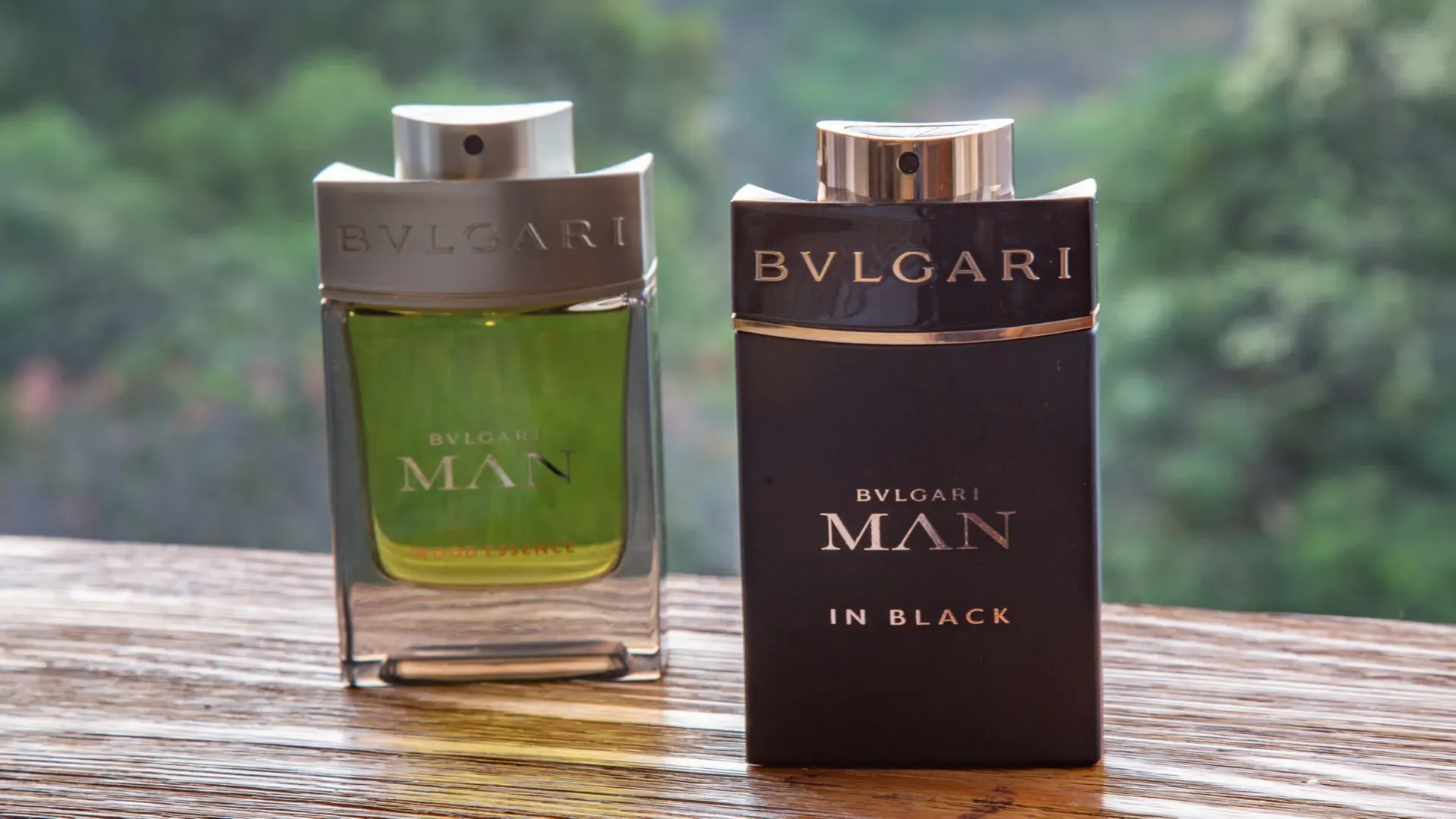 Dois Perfumes Bvlgari in Black alinhados com floresta ao fundo 