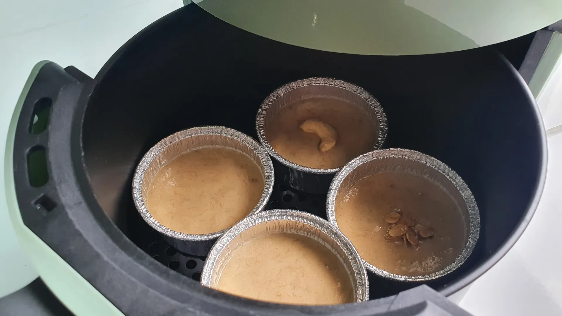 Cupcakes em forminhas sendo colocados para assar em uma airfryer