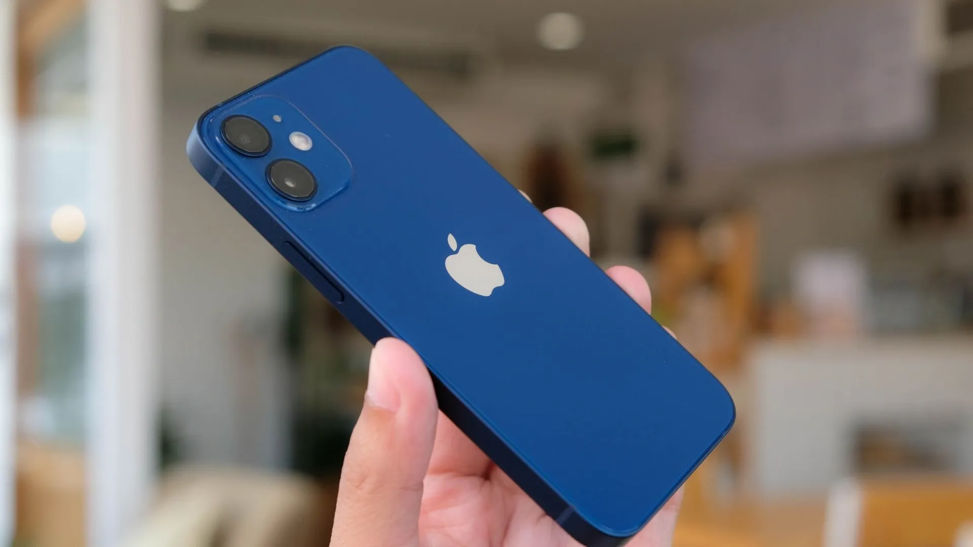 Smartphone pequeno iPhone 12 Mini azul em mão de homem