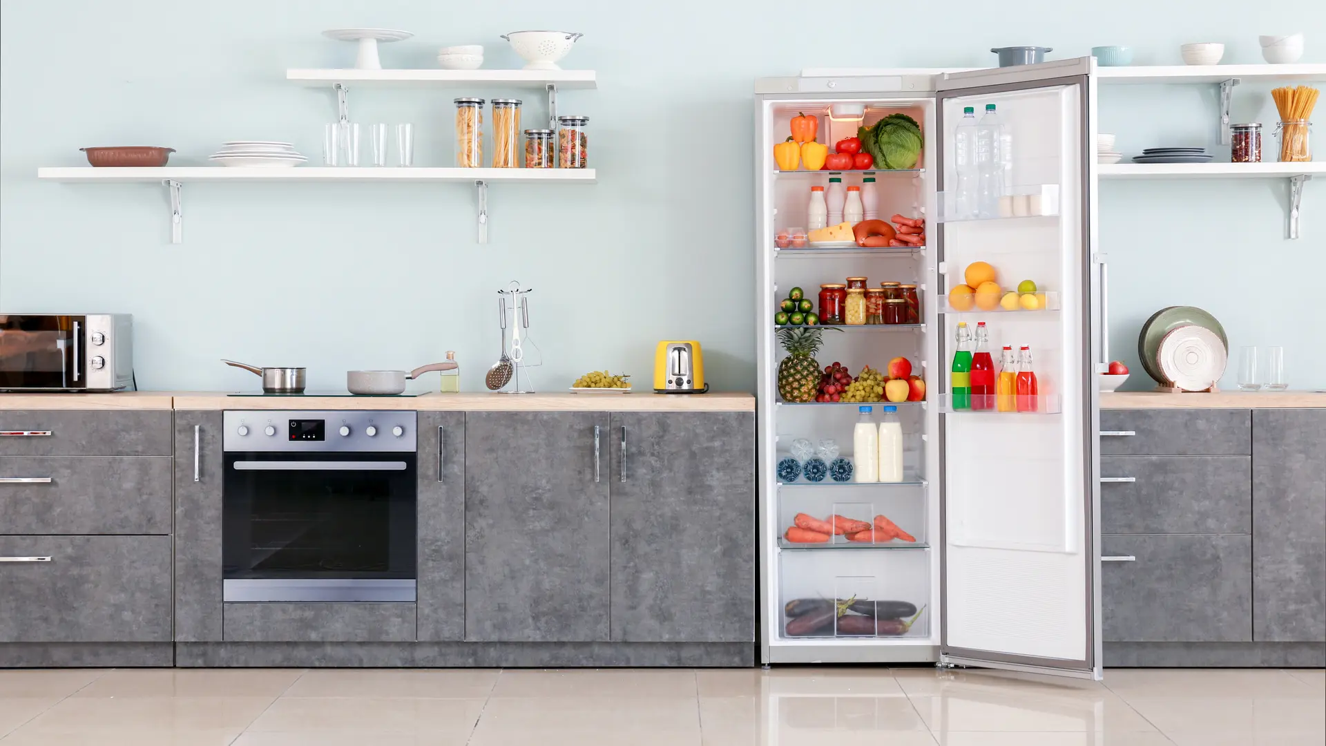 Foto de cozinha completa, com geladeira branca de uma porta aberta, com alimentos e bebidas dentro