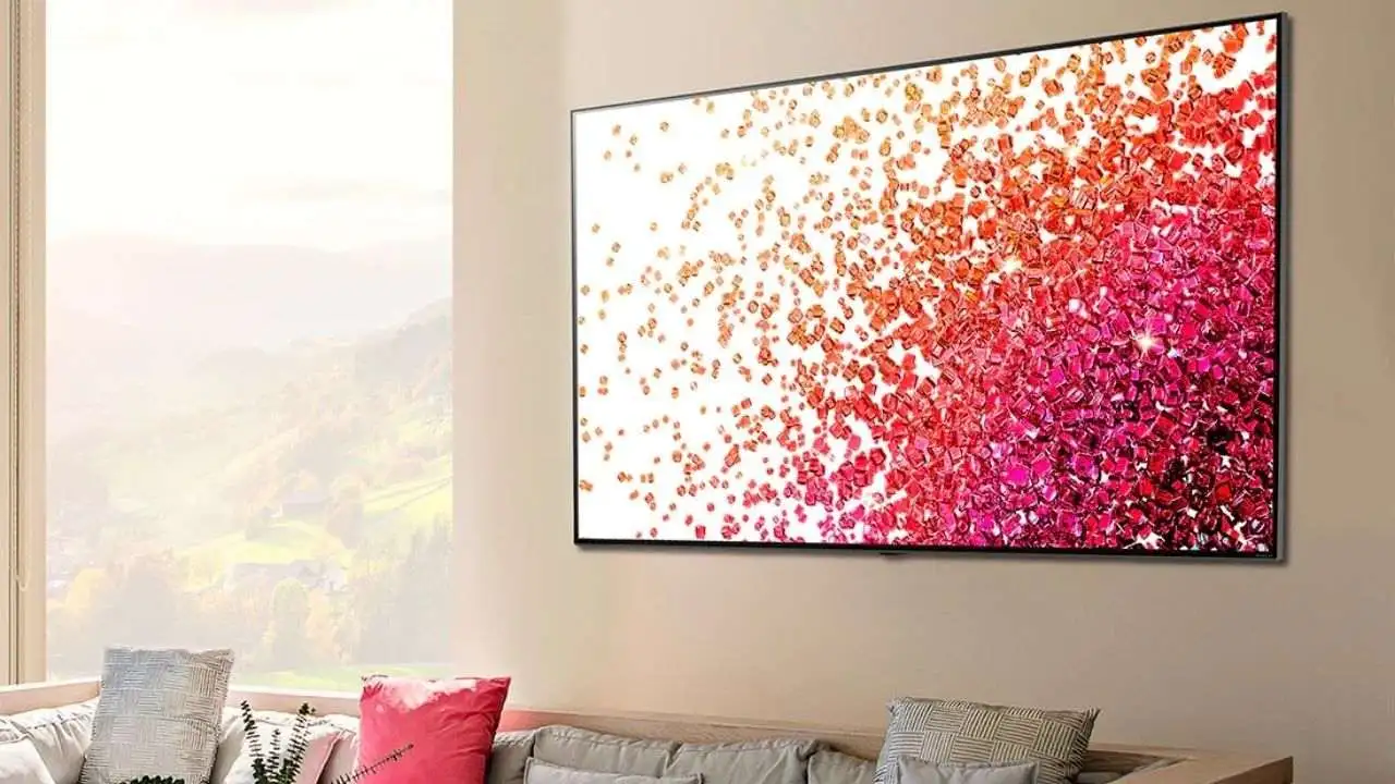 TV LG Nano75 de tela grande em parede de sala de estar, com sofá e almofadas abaixo dela