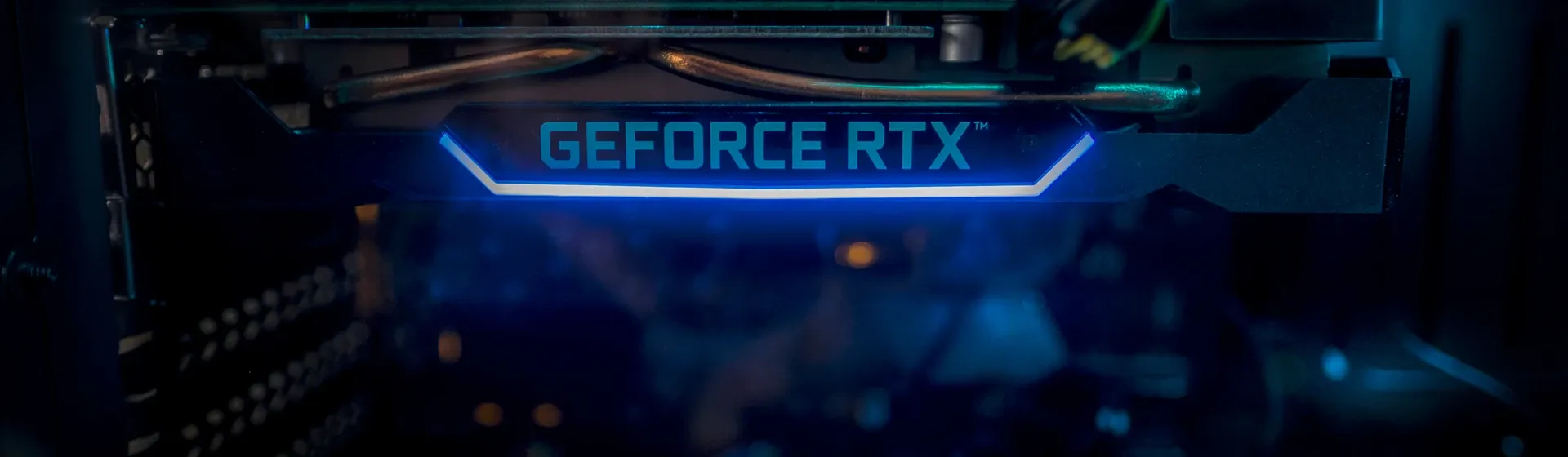 Interior de computador com destaque para placa de vídeo RTX com a inscrição "GEFORCE RTX" e LED azul  