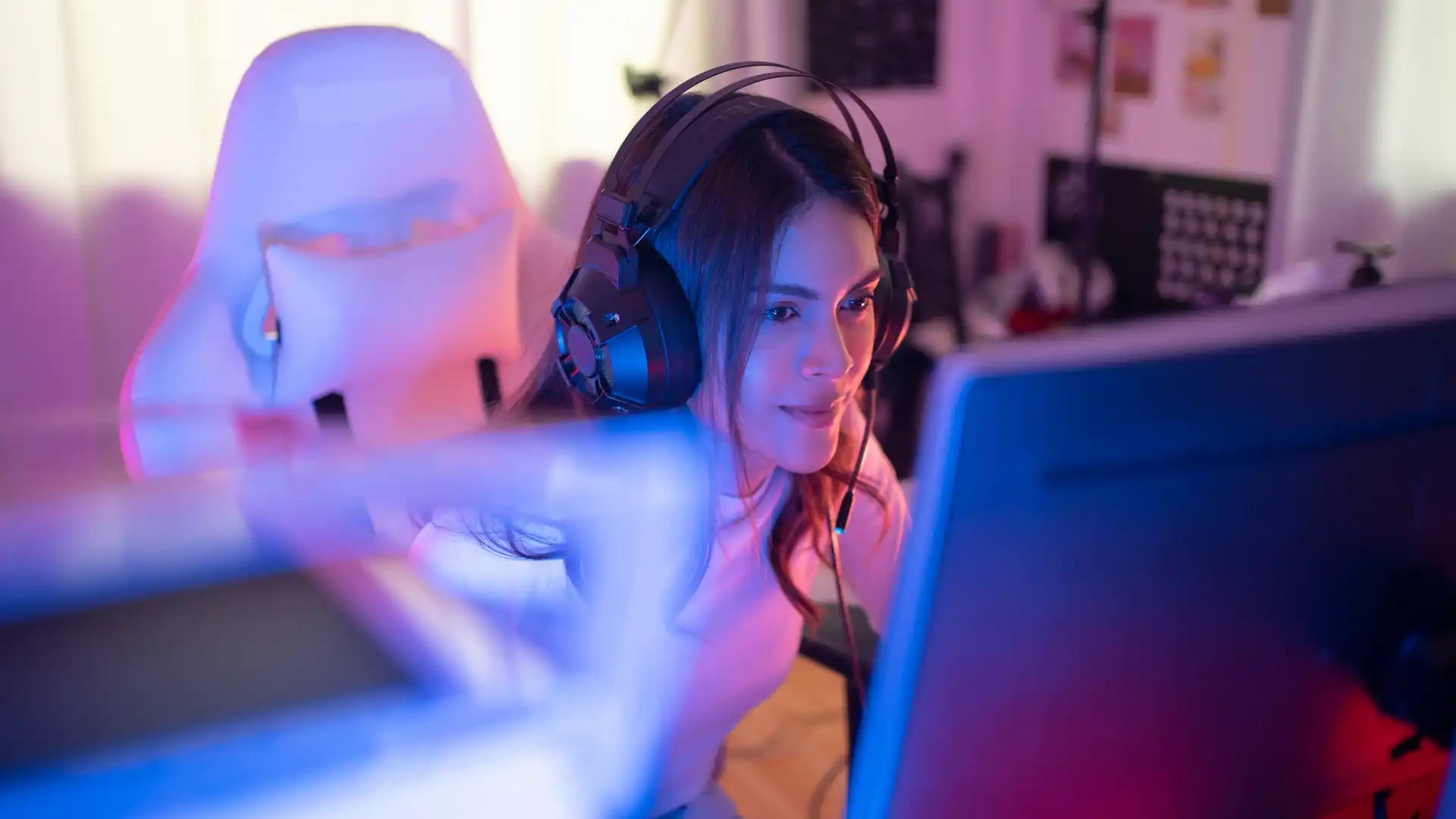 Menina com headset sentada em uma cadeira gamer branca interage com um monitor