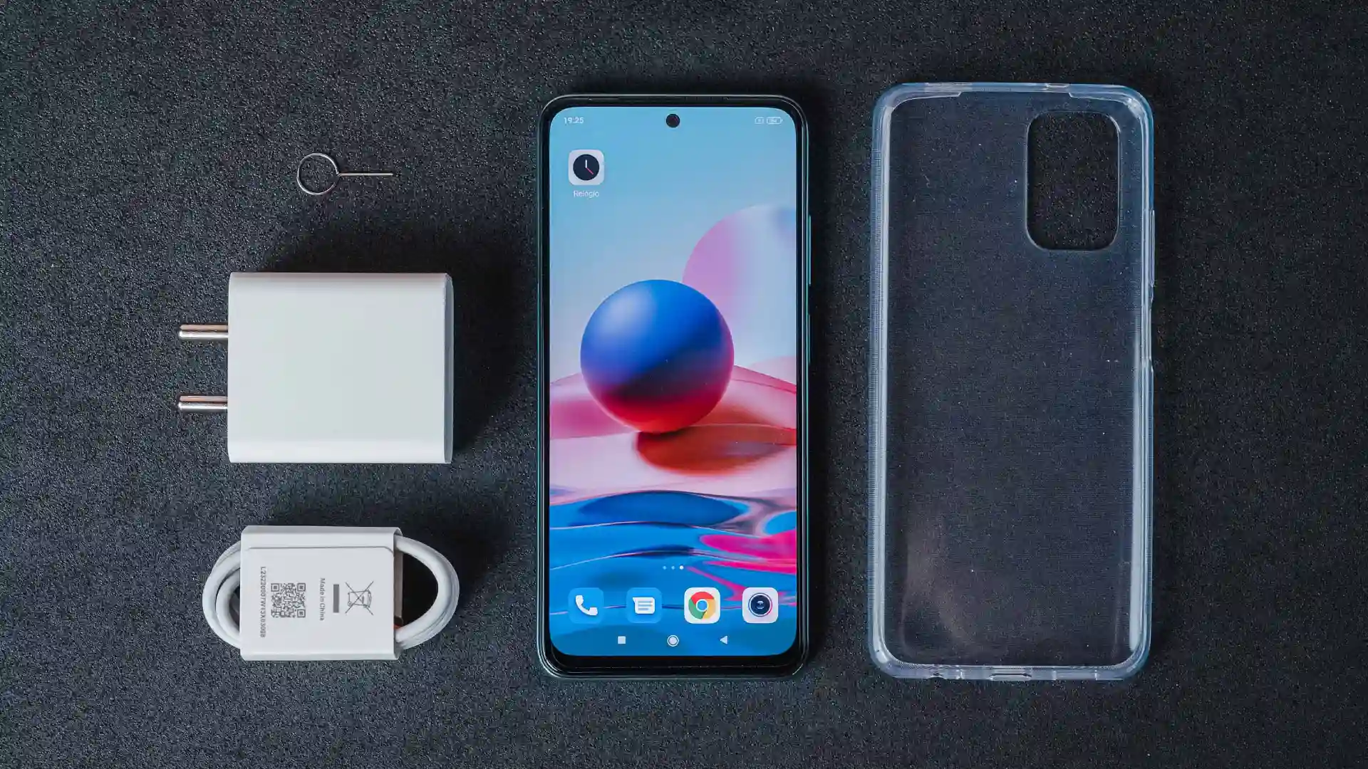 Redmi Note 10 ao lado do carregador e capa de silicone